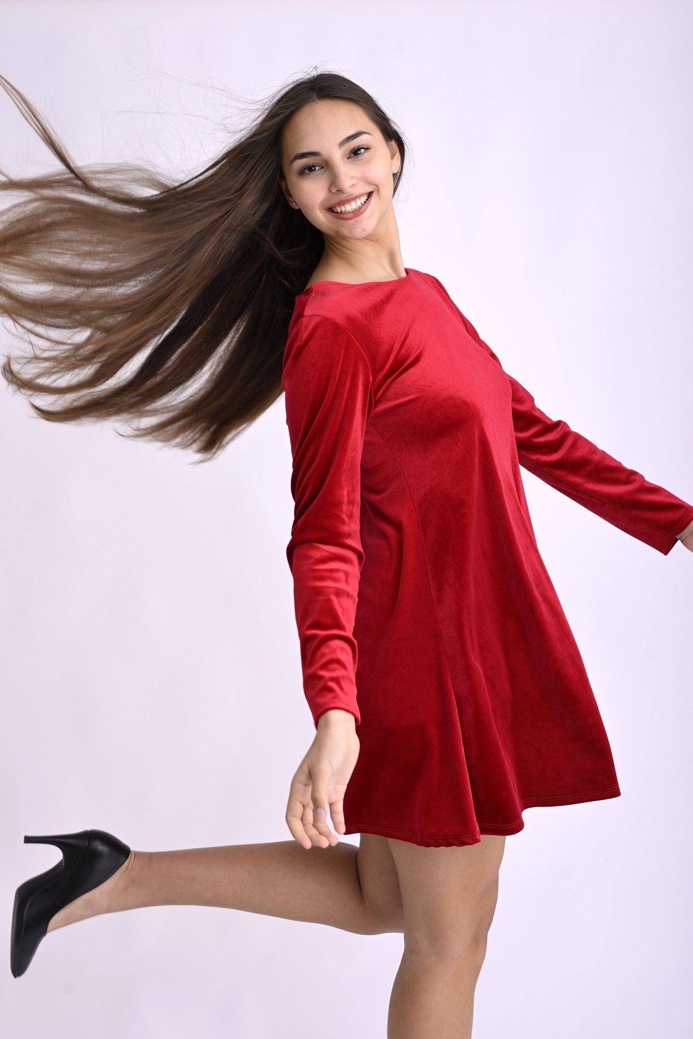 Rochie roșie din catifea fină, lejeră în mișcare, cu croială amplă și detaliu elegant la mâneci.