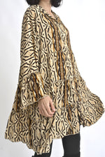 Vedere laterală a rochiei scurte din mătase, cu mâneci lungi ușor evazate și croială fluidă.