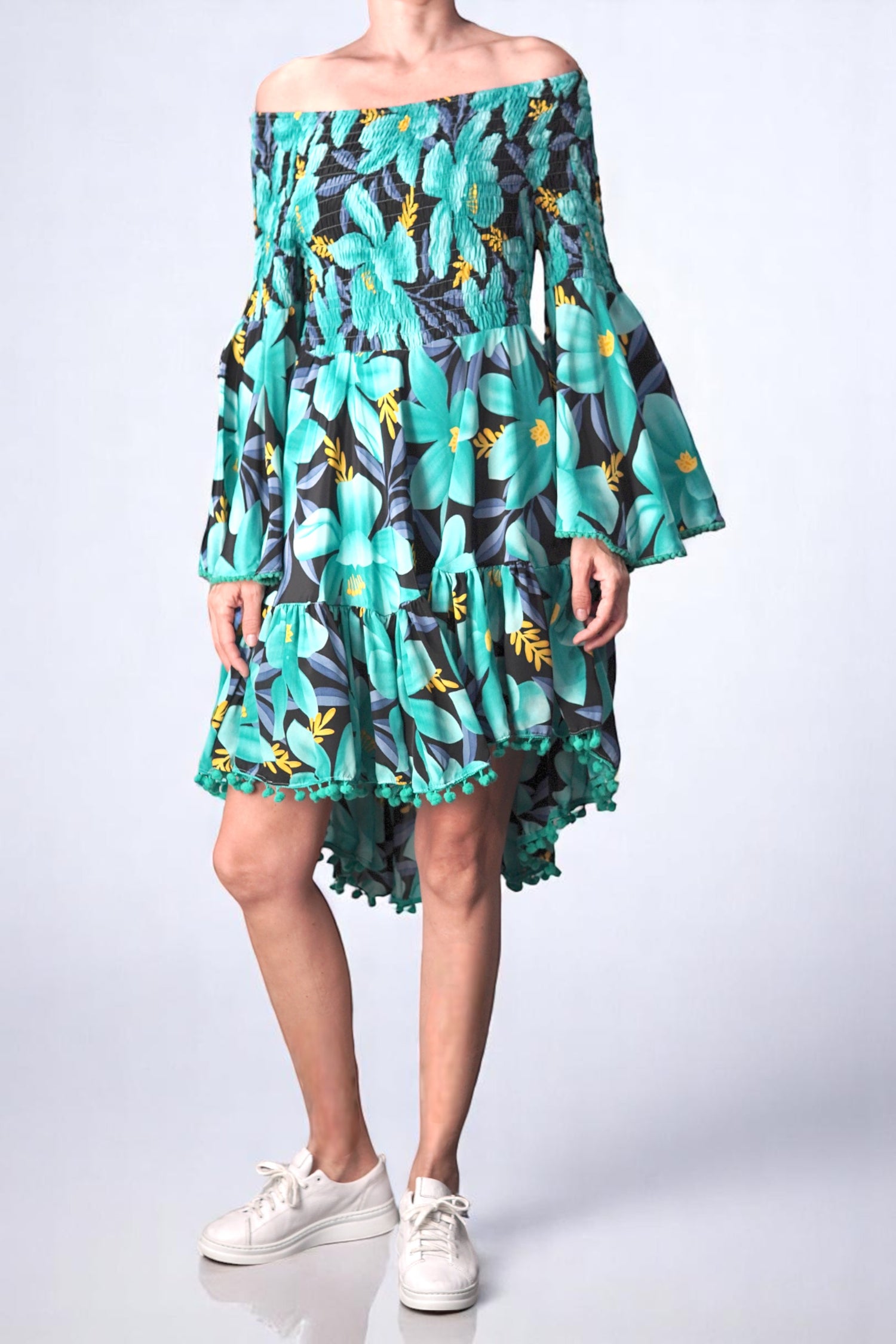 Rochie scurtă cu umeri goi, imprimeu floral turcoaz și galben, purtată de model din față