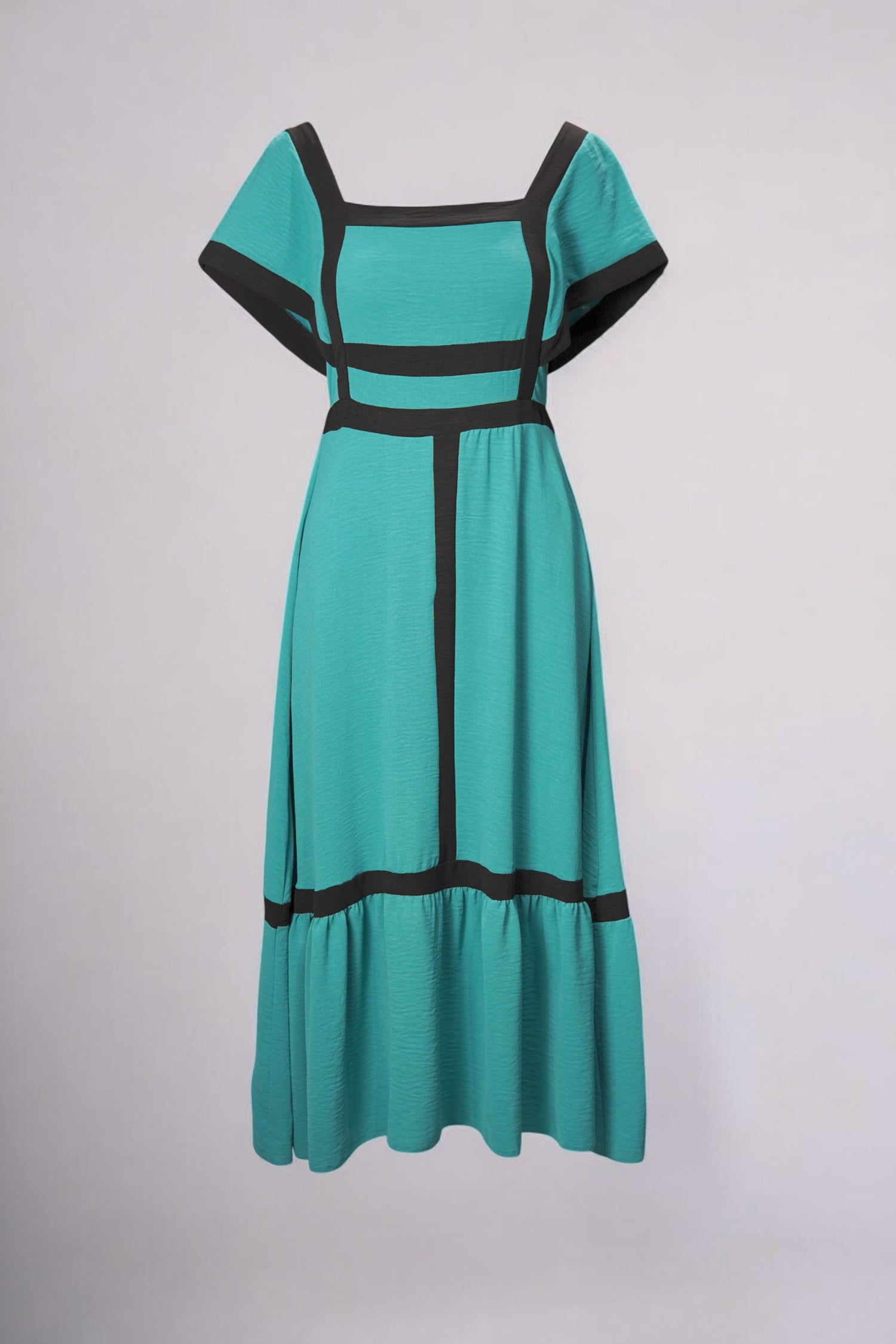 Rochie vaporoasă turcoaz cu decolteu pătrat și model geometric contrastant, stil boem și feminin.