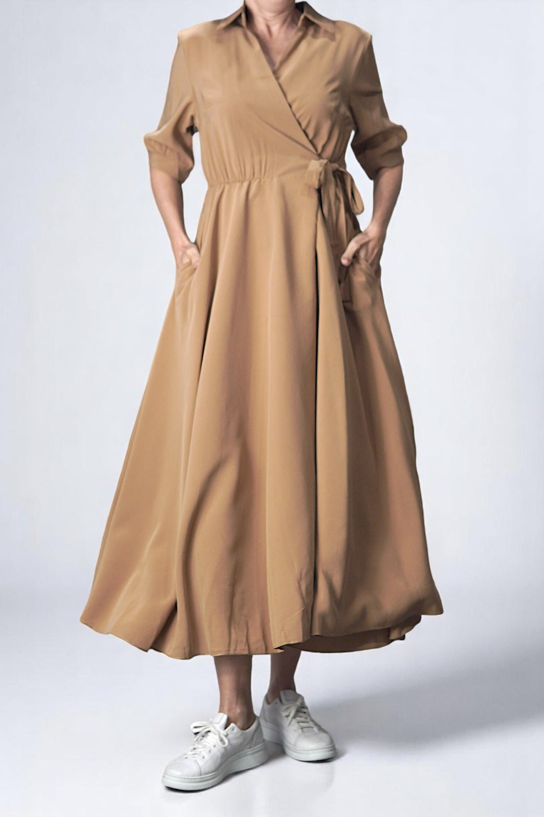 Rochie vaporoasă petrecută, cu guler rever și mâneci trei sferturi, în nuanță camel, prezentată pe model.