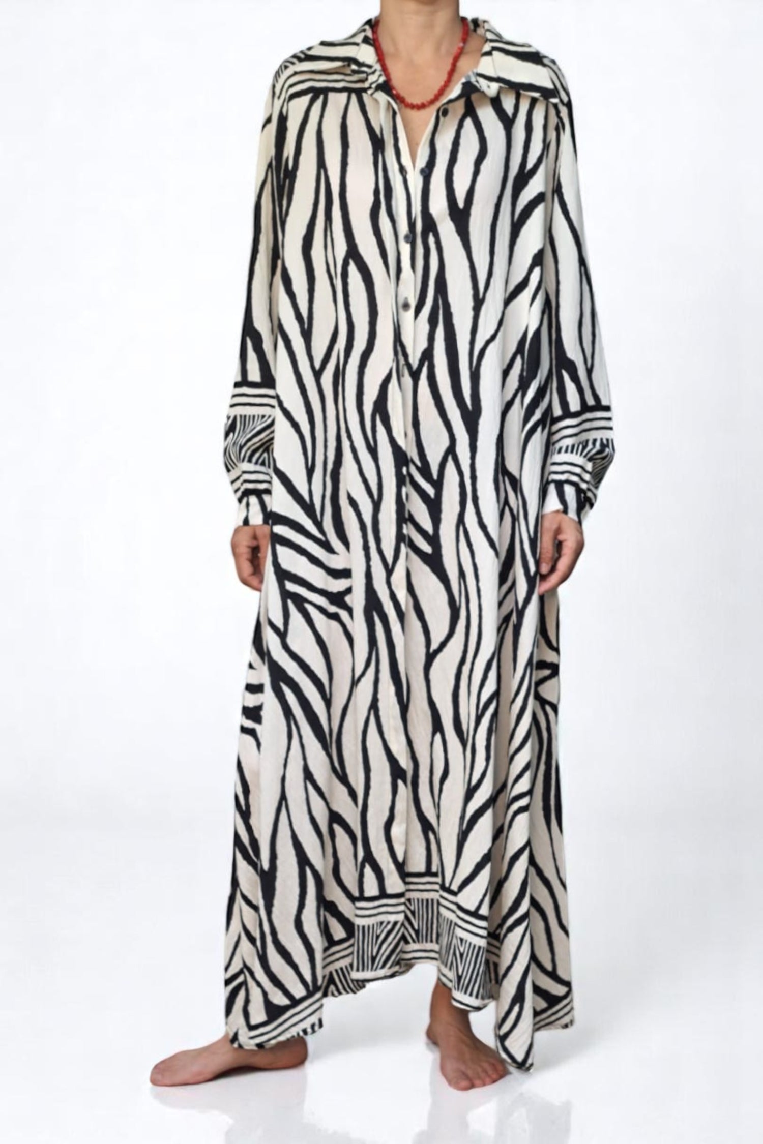 Rochie cu imprimeu zebra, din material vaporos, prezentată cu mâinile în buzunare pentru a evidenția croiala amplă.