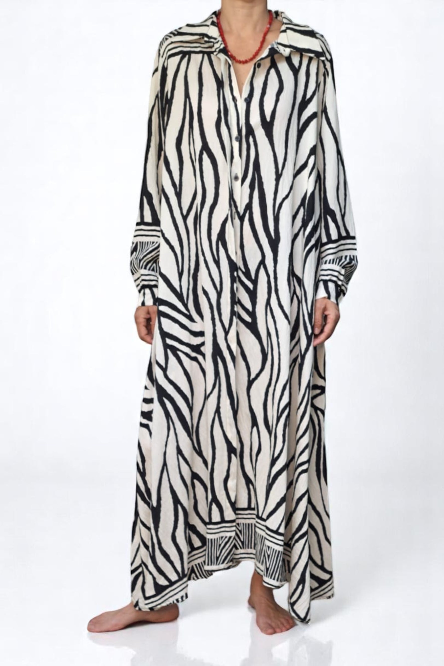 Rochie cu imprimeu zebra, din material vaporos, prezentată cu mâinile în buzunare pentru a evidenția croiala amplă.