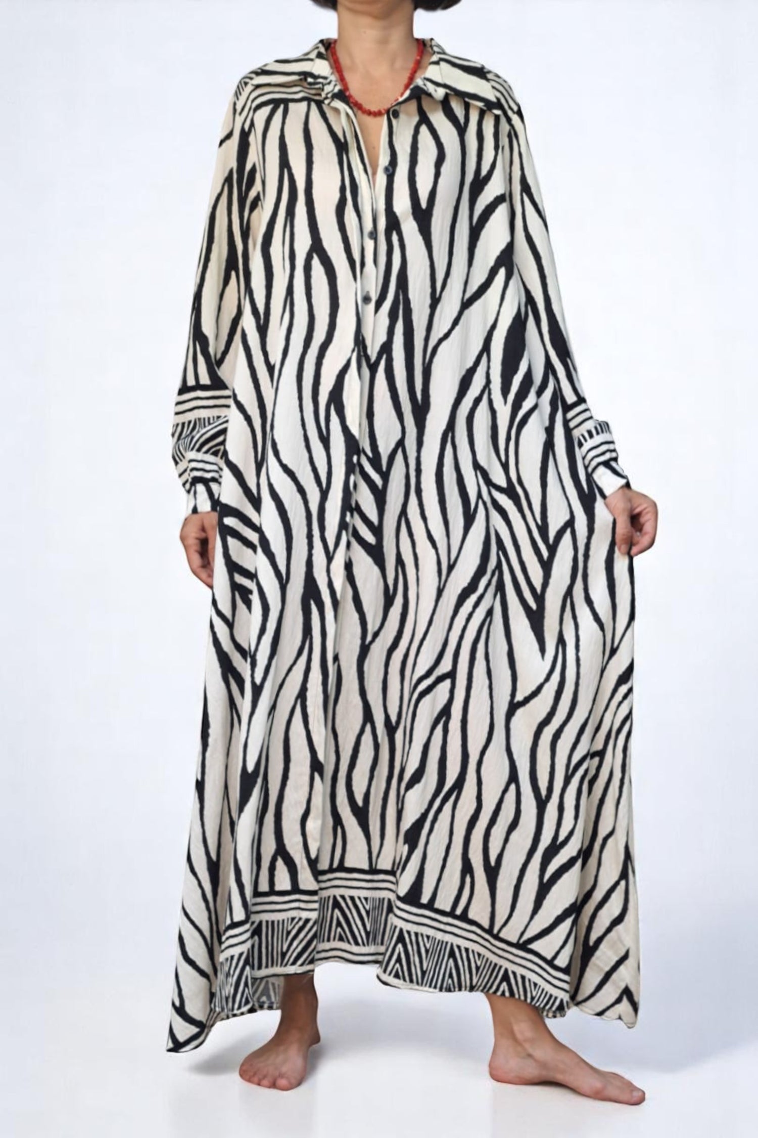 Rochie lungă cu imprimeu zebra alb-negru, croială lejeră și nasturi frontali, fotografiată din față.