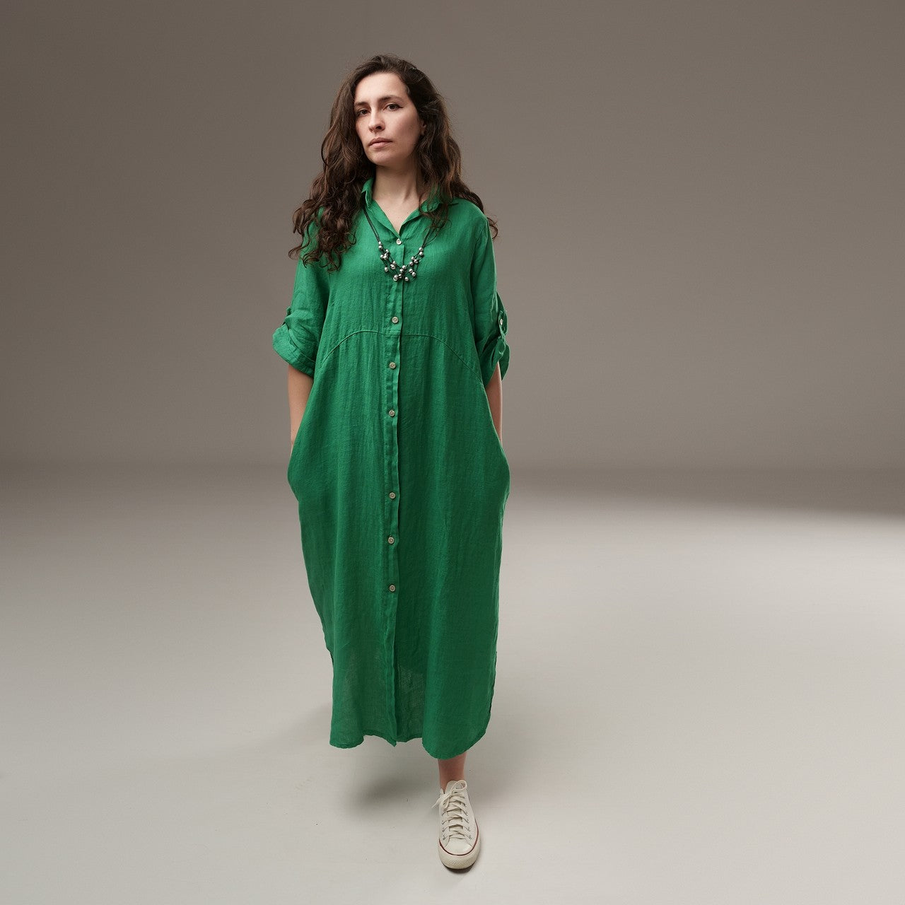 Rochie lungă verde tip cămașă din in, accesorizată cu colier, look boem și autentic.