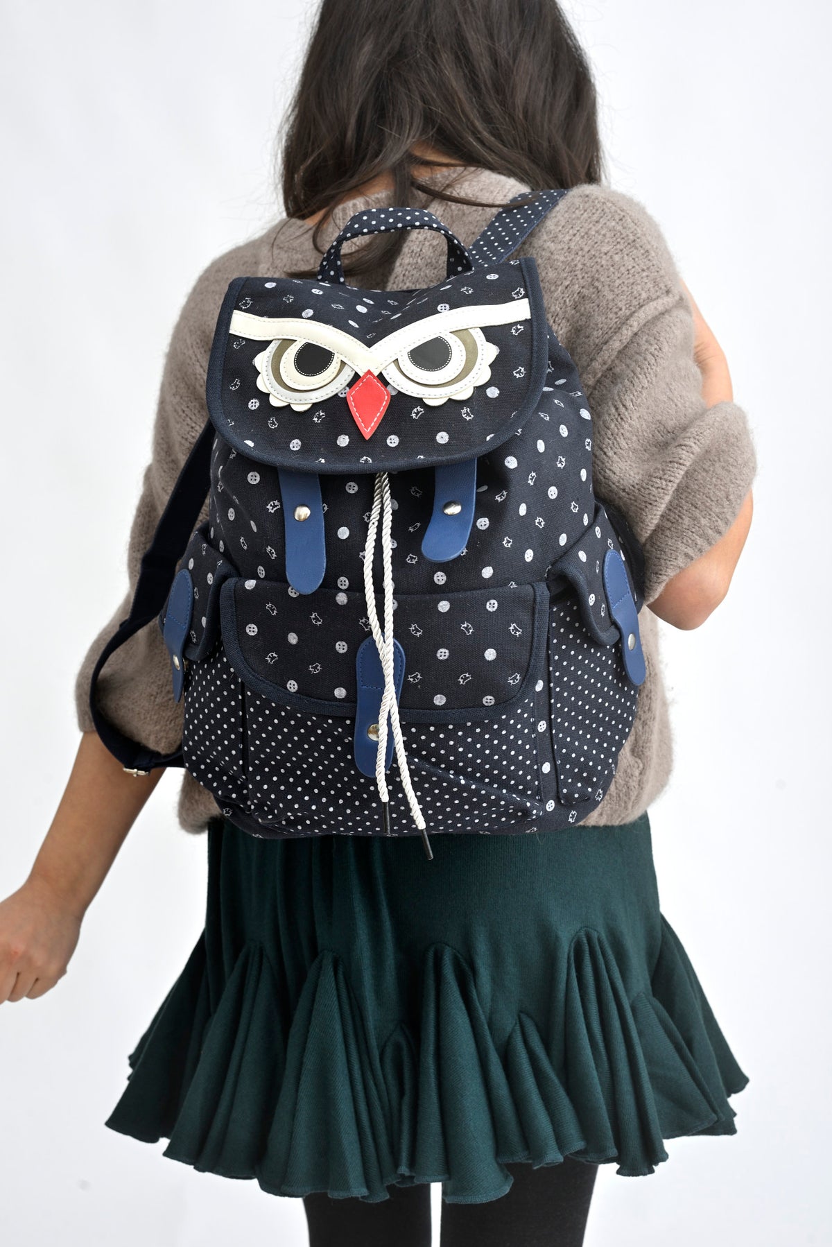 Rucsac bufniță bej din canvas, cu detalii contrastante, purtat într-o ținută de zi.