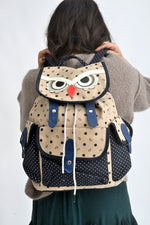 Rucsac din canvas cu buzunare laterale și imprimeu discret cu buline și simboluri.