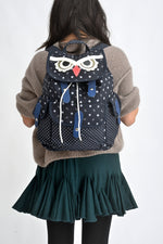 Detaliu frontal rucsac bufniță din canvas, cu clapetă decorativă și șnur de închidere.