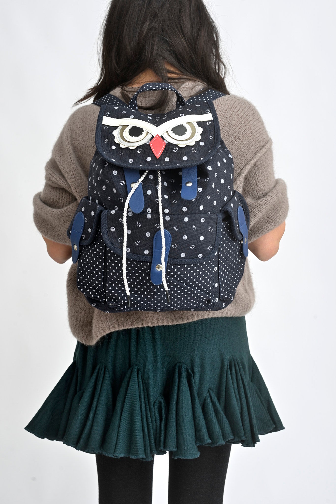 Detaliu frontal rucsac bufniță din canvas, cu clapetă decorativă și șnur de închidere.