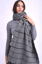 Șal gri minimalist cu dungi fine și textură moale, purtat lejer peste un pulover gri.