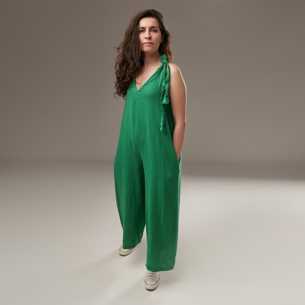 Salopetă culotte din in verde, cu bretea legată în nod pe umăr, decolteu în V și croială lejeră, vedere frontală pe model.
