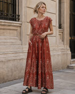Salopetă lungă cărămizie satinată cu decupaj la spate și imprimeu floral, vedere frontală. All Above Boutique.