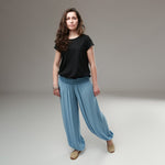 Pantaloni largi bleu cu talie plisată, purtați cu un tricou negru