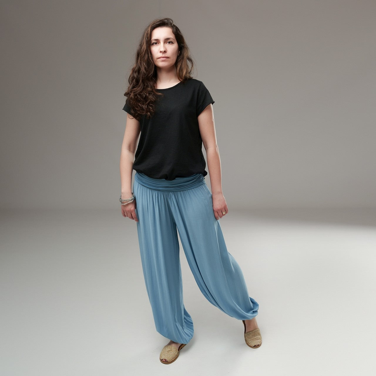 Pantaloni largi bleu cu talie plisată, purtați cu un tricou negru