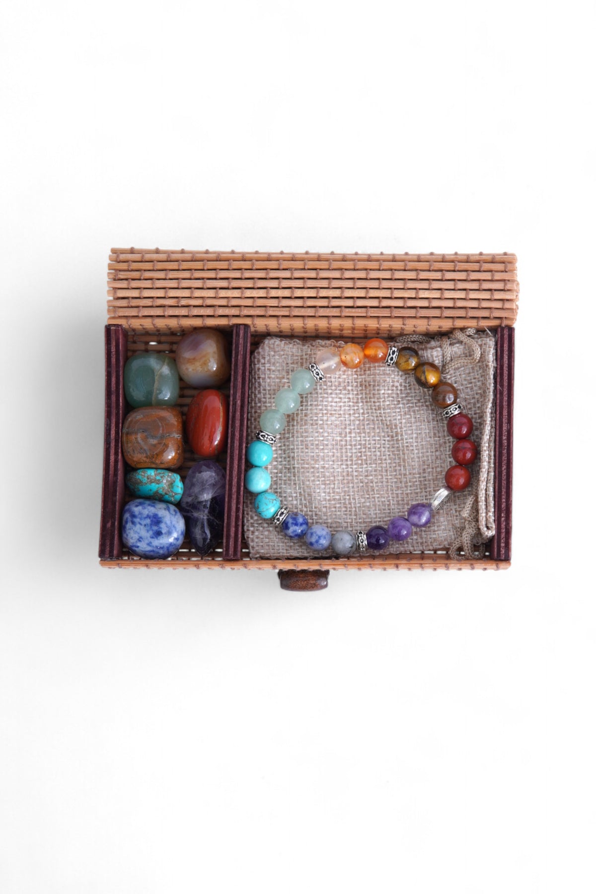 Cutia împletită a setului de cristale, închisă, surprinsă pe fundal alb.