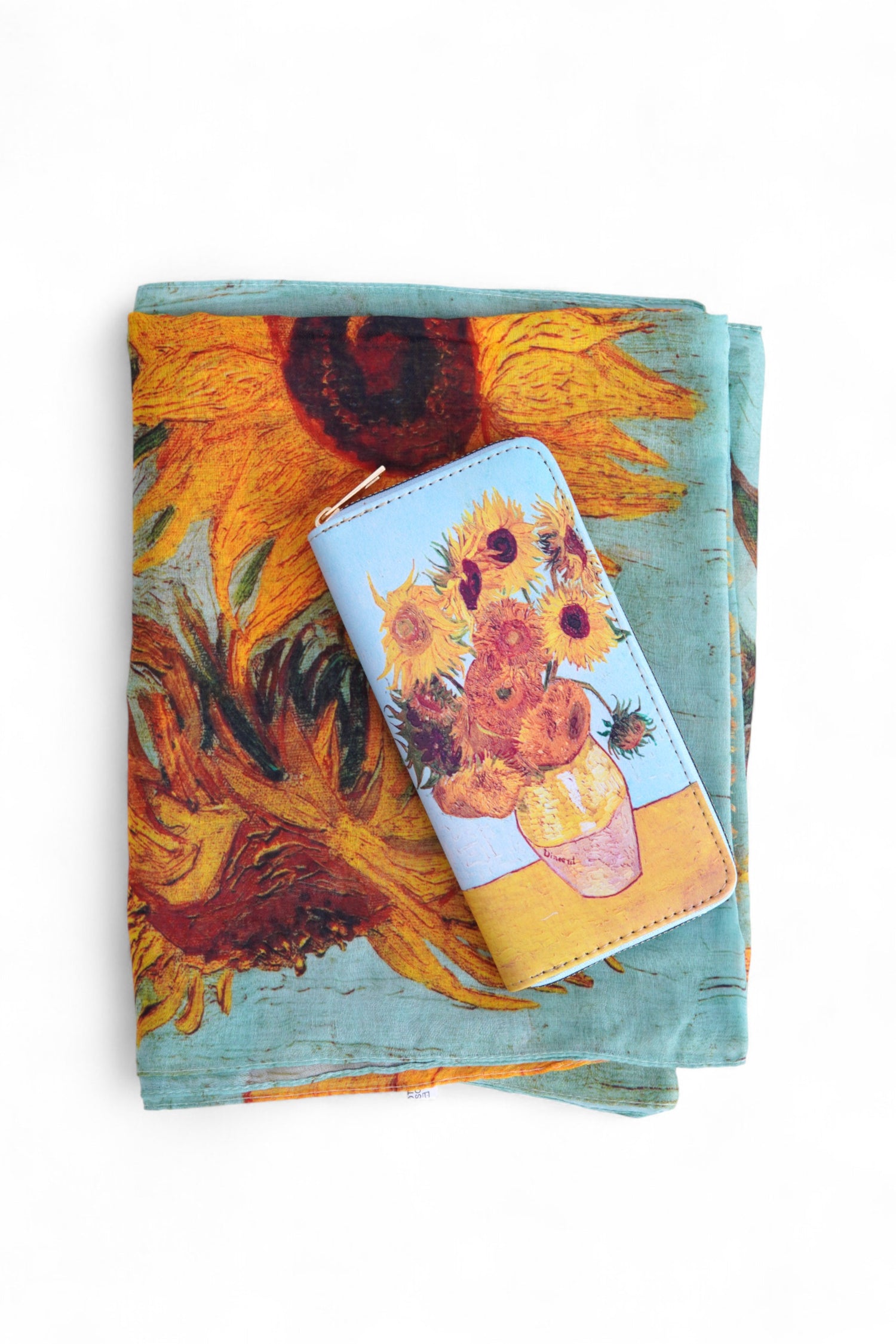 Set eșarfă și portofel cu imprimeu Floarea Soarelui, în nuanțe calde de portocaliu și galben, prezentate împreună pe fundal alb.