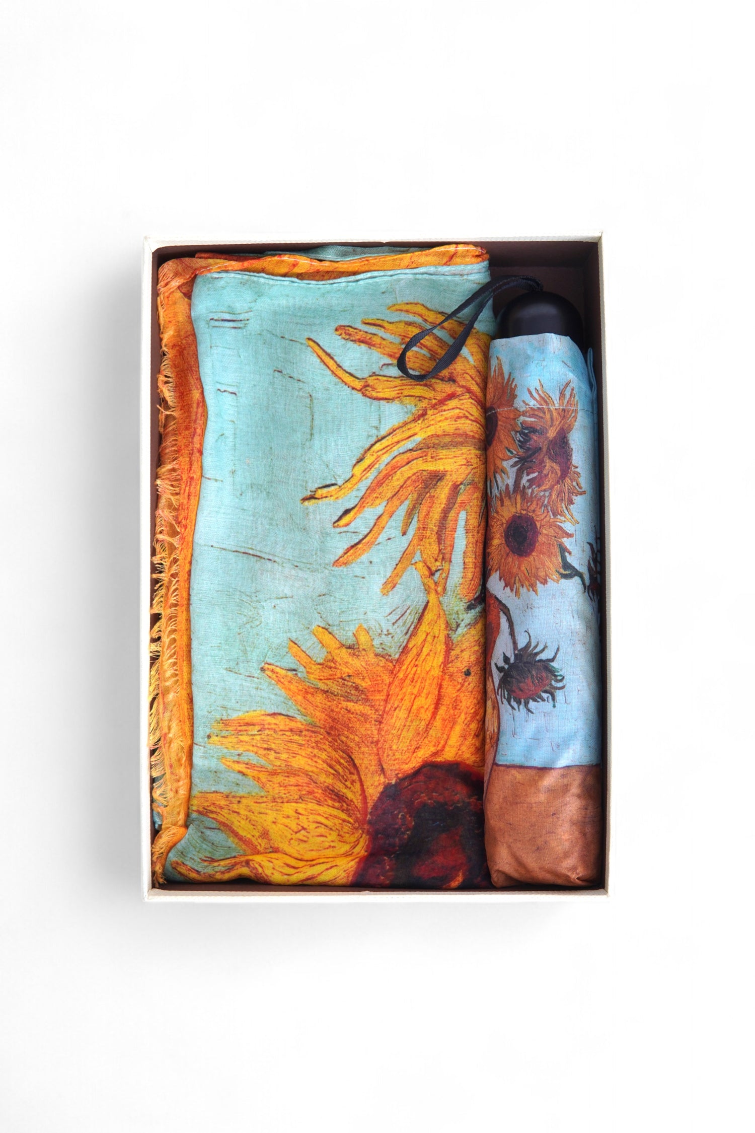 Eșarfă și umbrelă în culori calde, prezentate împreună într-un format compact, gata pentru cadou.