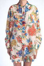 Cămașă lejeră cu imprimeu floral viu colorat, purtată cu pantaloni scurți asortați.