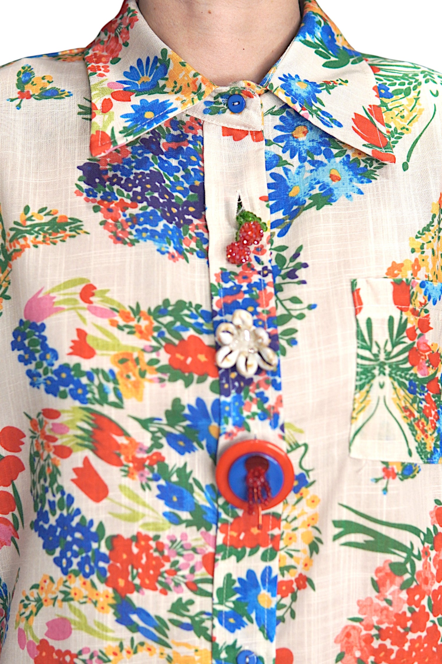 Detaliu al gulerului și nasturilor decorativi ai cămășii cu imprimeu floral multicolor.