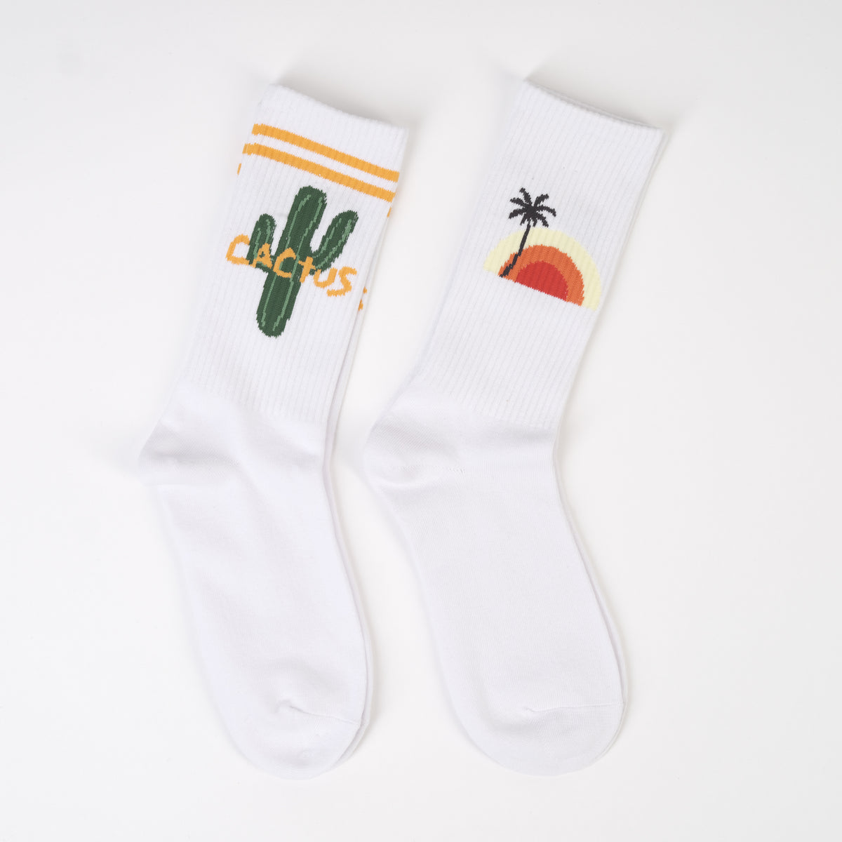 Set de două șosete tricotate albe cu imprimeuri diferite: palmier și cactus.