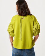 Tricou verde lejer din jerse, vedere din spate cu detaliu inserții mătăsoase. All Above Boutique.