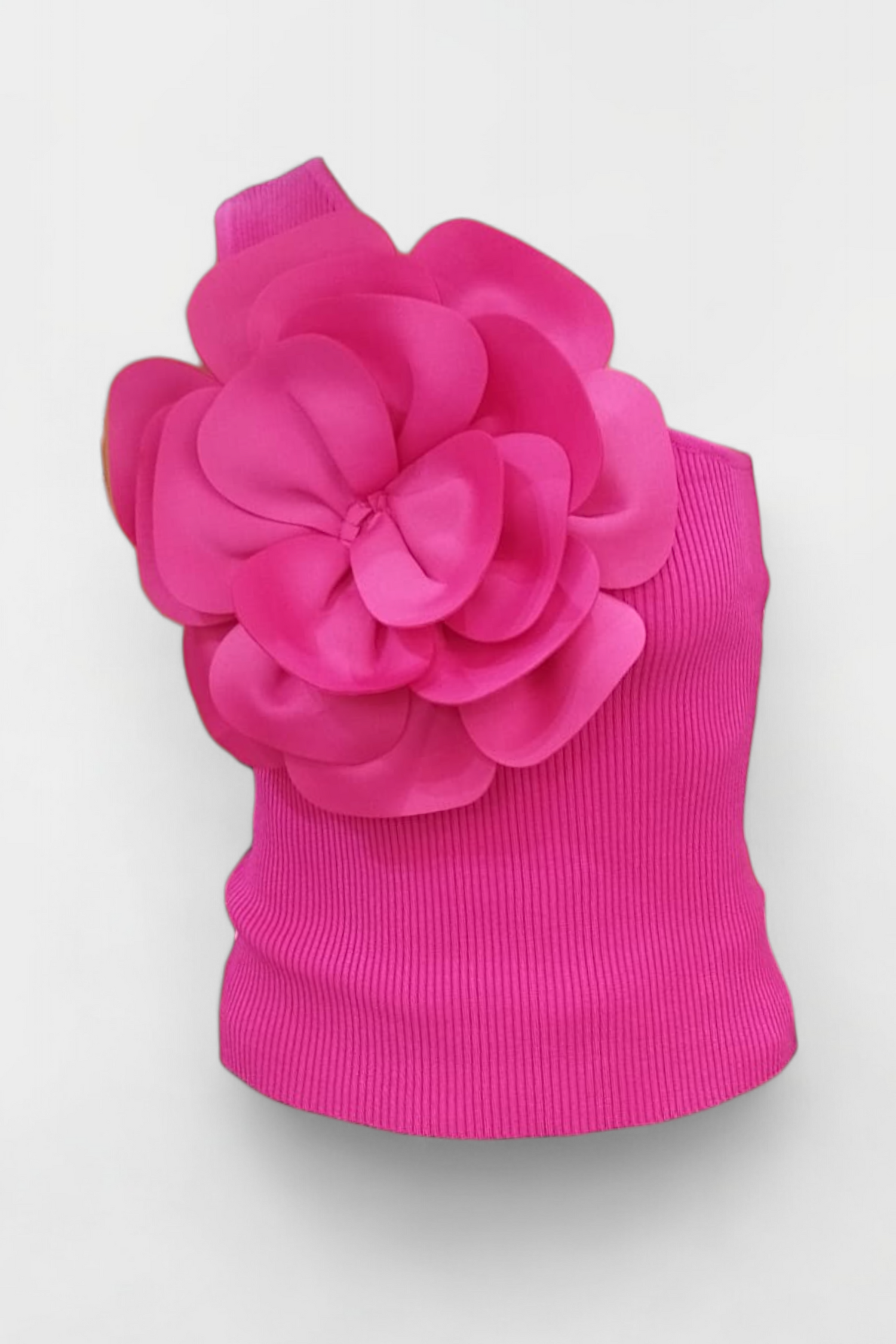 Top fucsia asimetric, cu floare mare în relief aplicată pe umăr, confecționat din rib elastic.