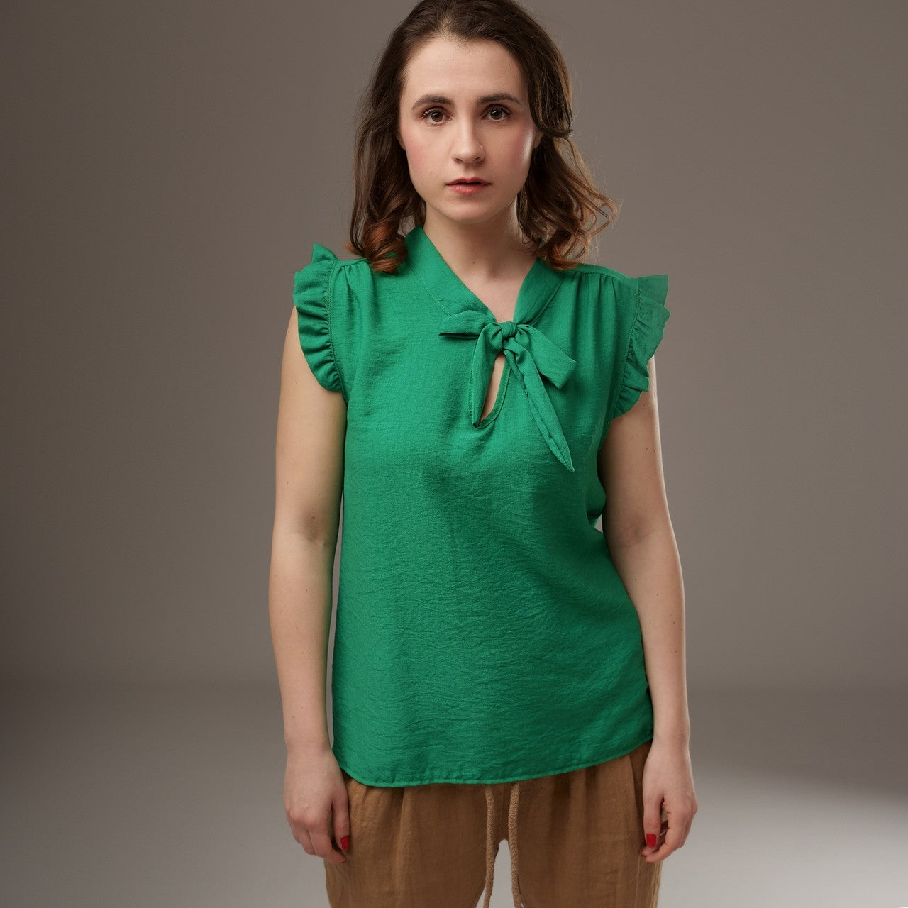 Top verde lejer, cu cravată la decolteu în V și volănașe delicate la umeri.