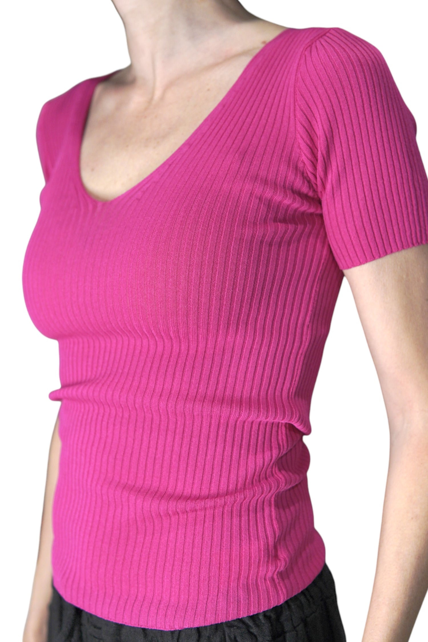 Vedere laterală a unui top fucsia mulat, cu textură reiată și croială feminină