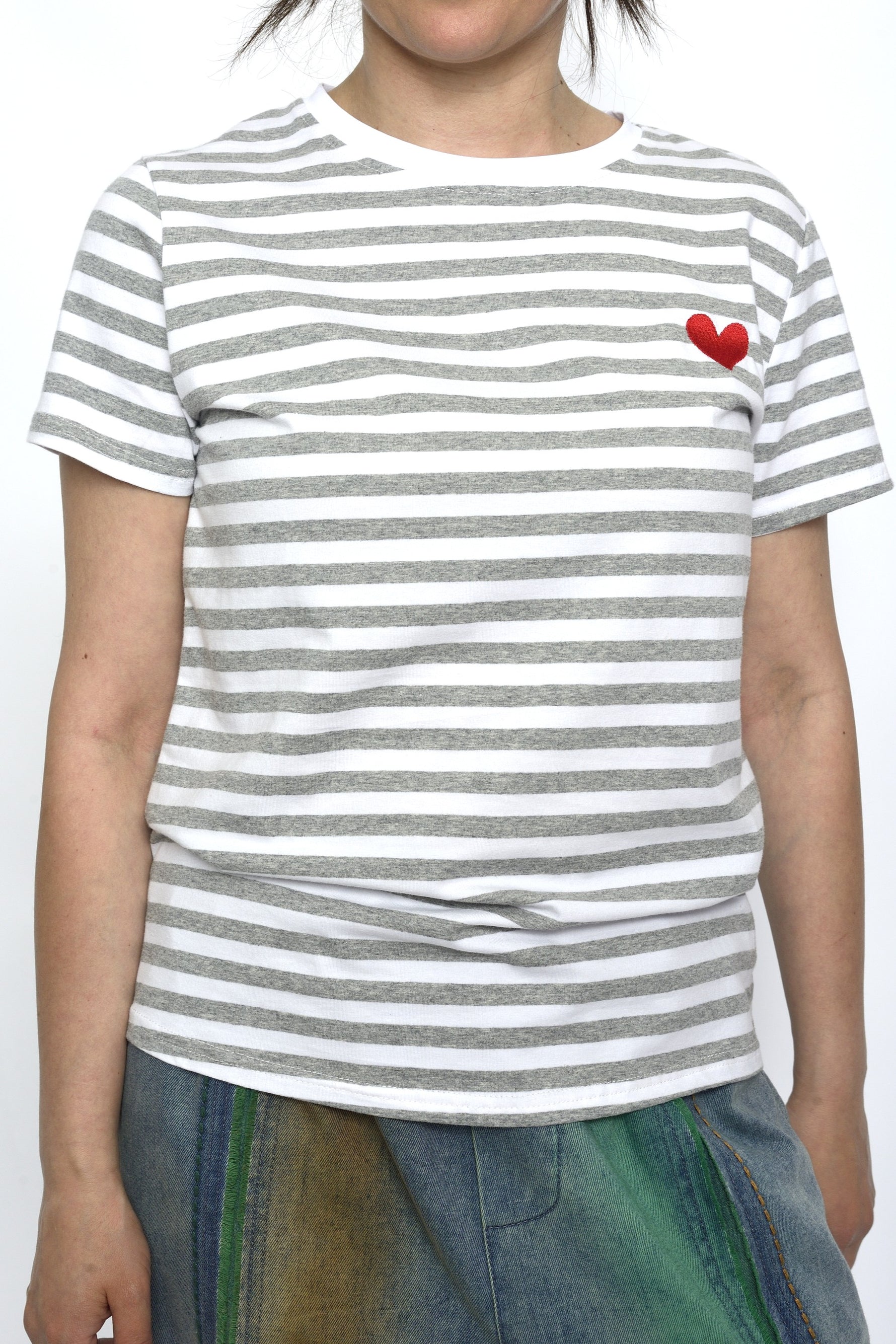  Tricou alb cu dungi gri și inimă roșie brodată pe piept, purtat cu fustă din denim