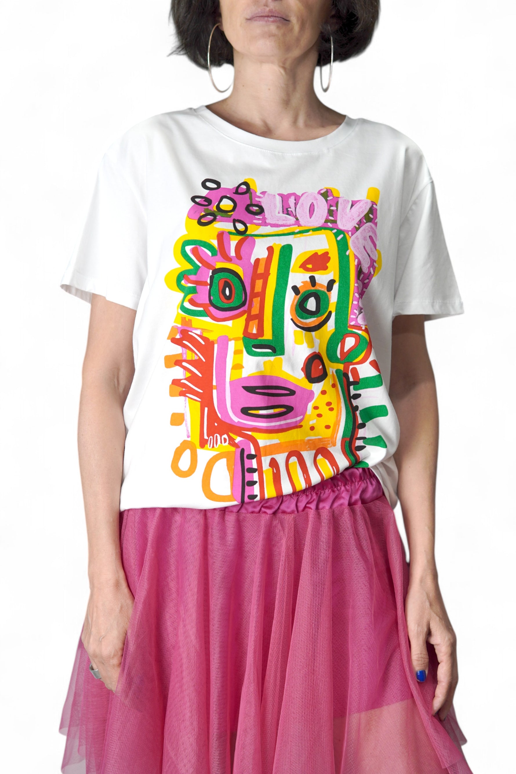 Tricou alb din bumbac cu imprimeu abstract colorat în nuanțe vibrante de roz, galben, verde și portocaliu, purtat cu o fustă tul fucsia
