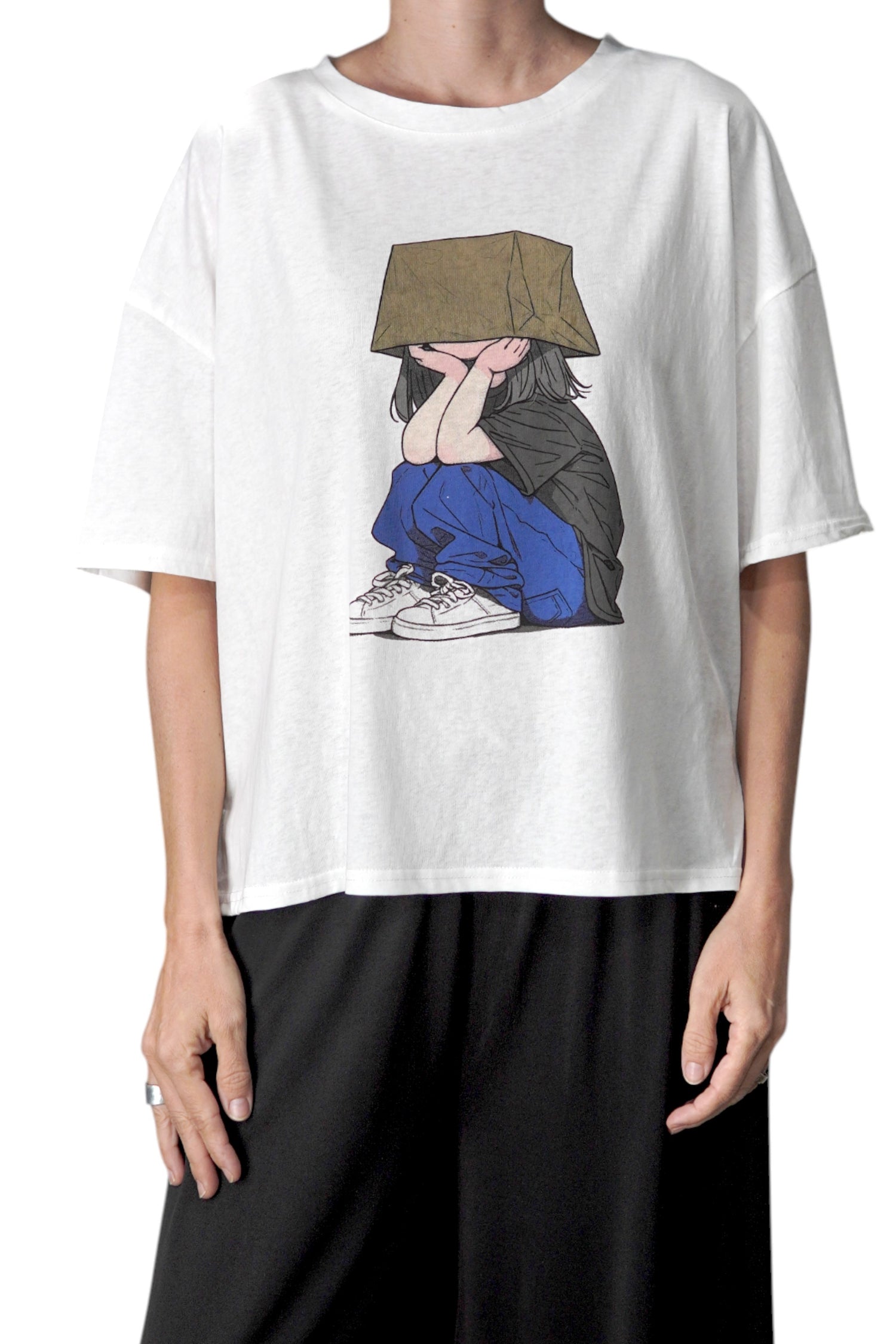 Tricou alb oversized cu imprimeu colorat cu o fată desen animat, purtat de model.