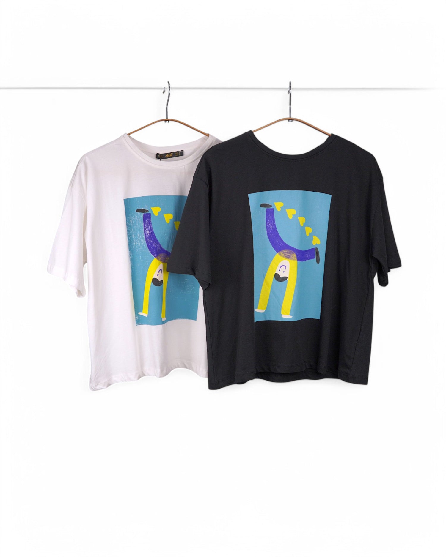 Variante culori tricouri alb si negru  din bumbac cu print artistic – băiat cu inimi galbene pe fundal albastru, croială lejeră și modernă.