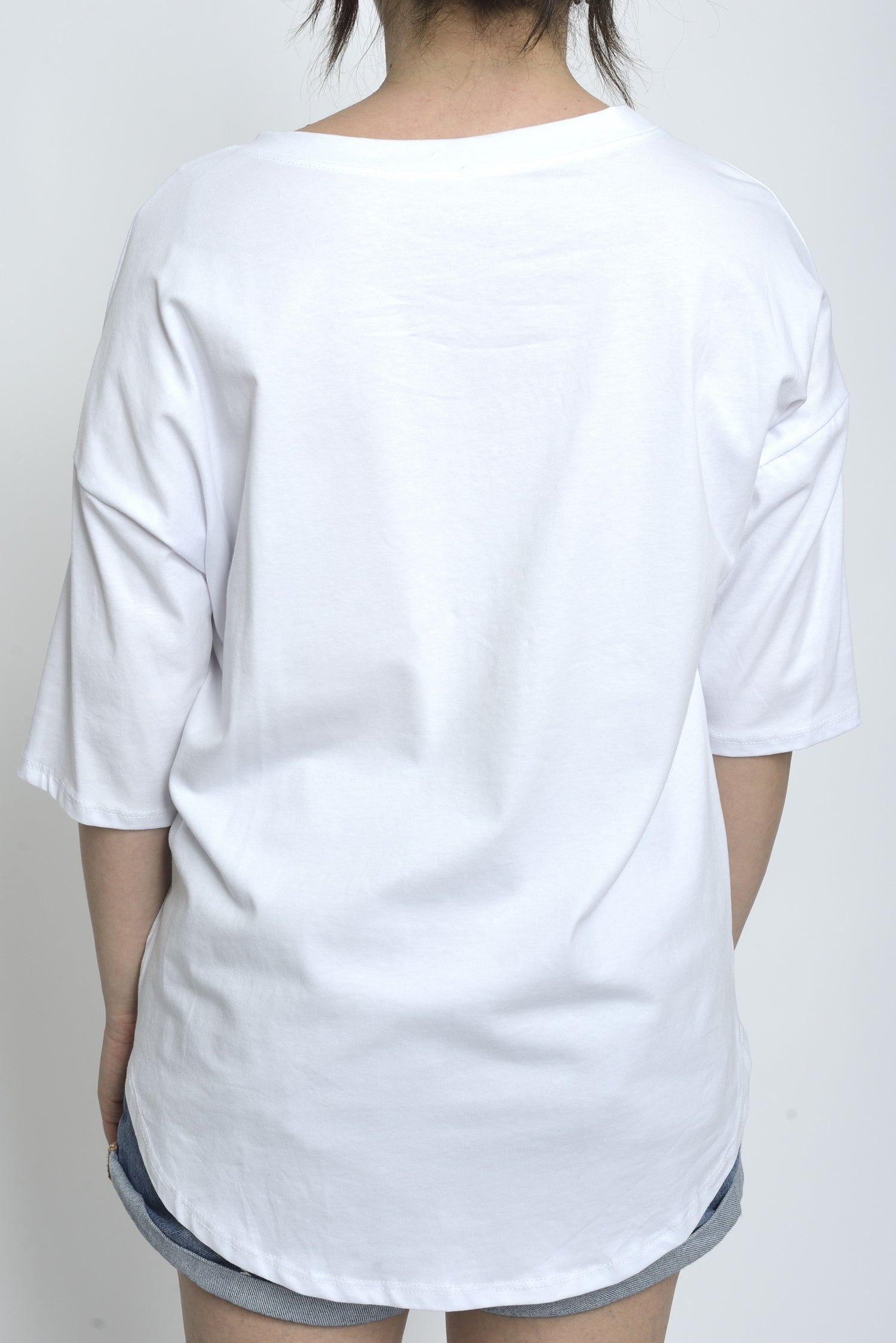 Spatele unui tricou alb simplu, fără imprimeu, cu croială lejeră