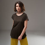  Tricou kaki în stil minimalist, cu mâneci scurte și croială ușor evazată, purtat de model cu pantaloni galbeni.