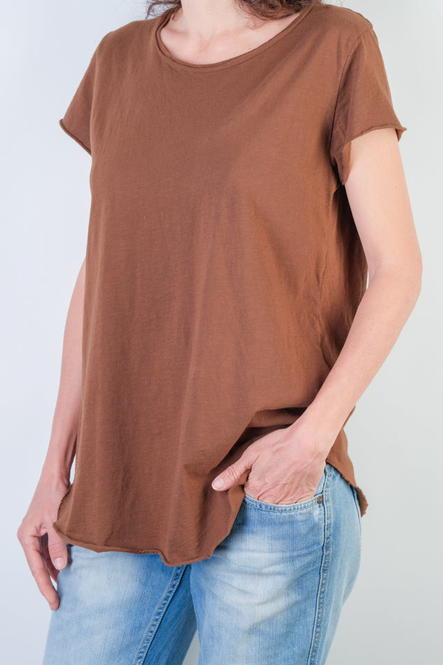 Detaliu textură și croială a unui tricou maro din bumbac, cu mânecă scurtă și bază rulată.