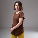 Tricou maro simplu din bumbac, văzut din lateral pe model, cu croială lejeră și guler rotund.