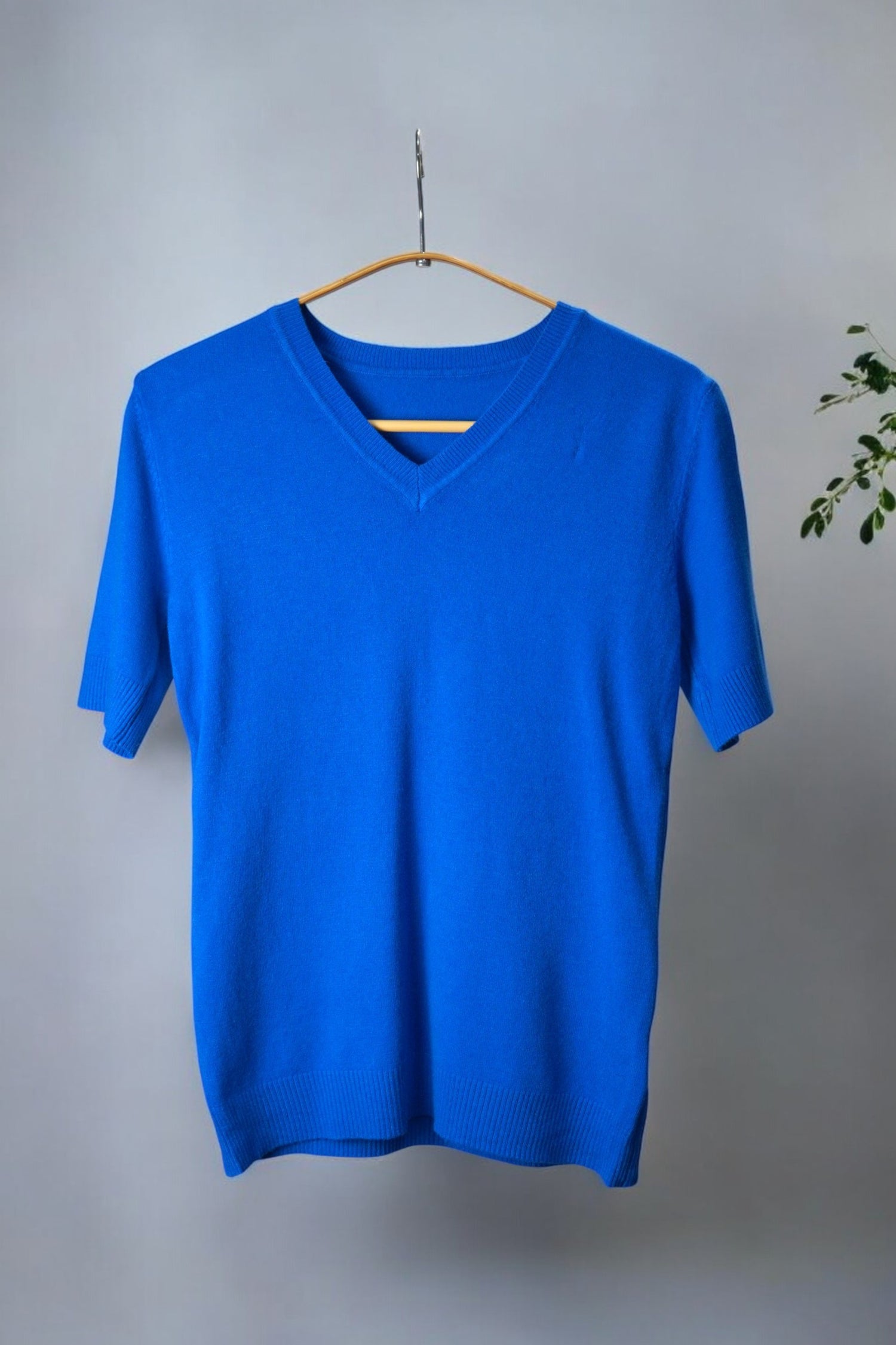 Tricou casual albastru cu decolteu în V și mânecă scurtă, confecționat din material fin și elastic, ideal pentru ținute relaxate.