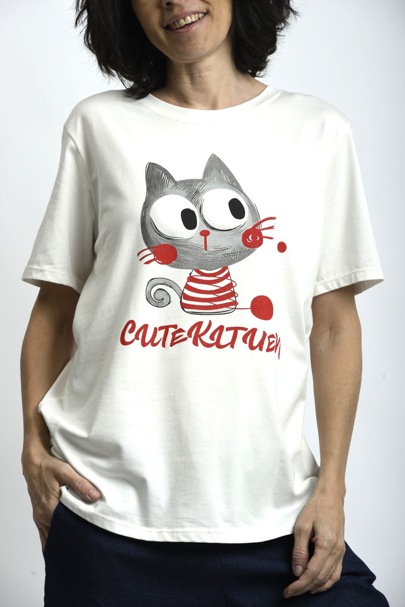 Detaliu imprimeu pisicuță pe tricou alb, grafic jucăuș cu accente roșii, aspect clar și bine definit.
