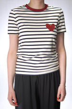  Tricou cu dungi alb-negru și inimă roșie aplicată pe piept, văzut din față.