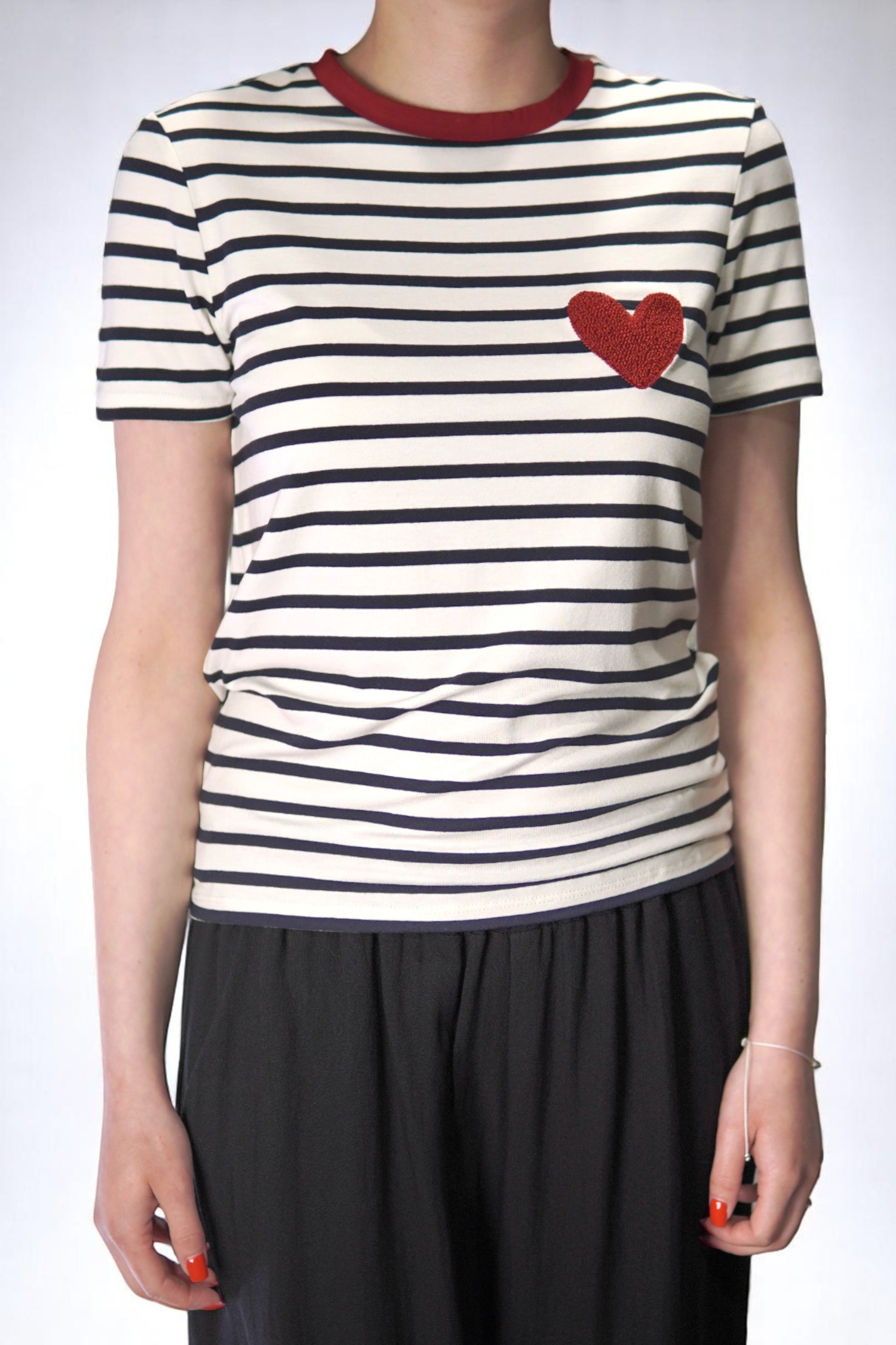  Tricou cu dungi alb-negru și inimă roșie aplicată pe piept, văzut din față.