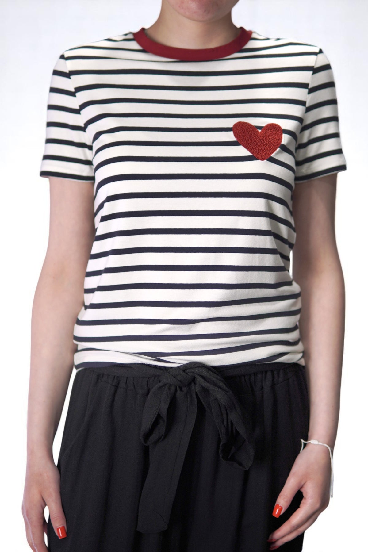Tricou cu dungi și inimă roșie purtat cu nod decorativ în talie.