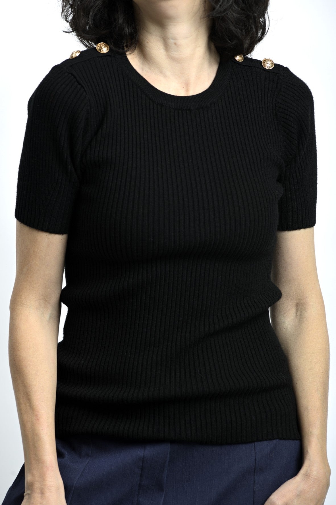 Detaliu cu nasturi pe umăr la tricou slim negru, accent discret cu rol estetic.