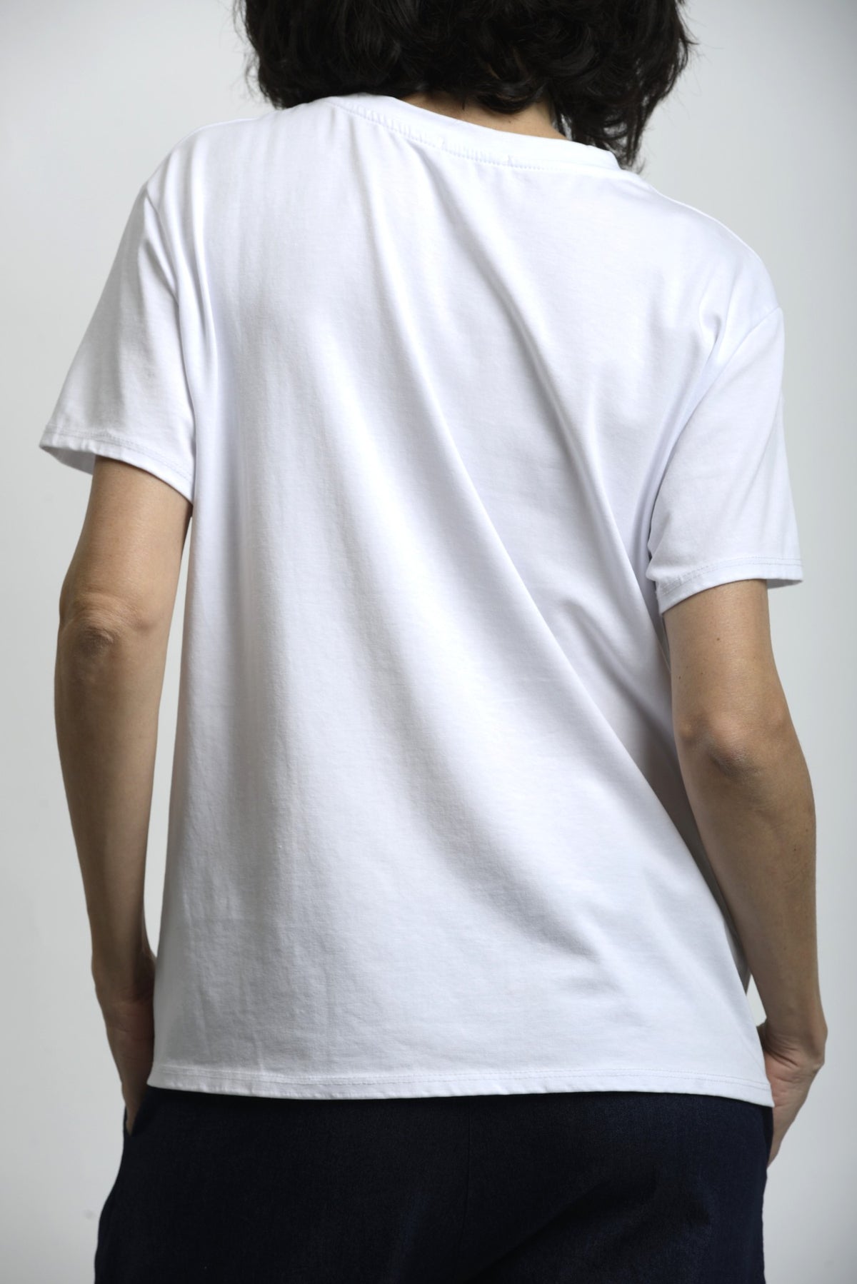 Tricou alb cu Snoopy, vedere din spate, design simplu și croială confortabilă.