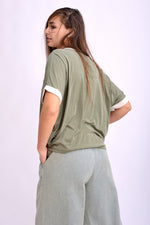 Tricou verde din vâscoză striată cu umeri căzuți și margine contrastantă la mânecă.