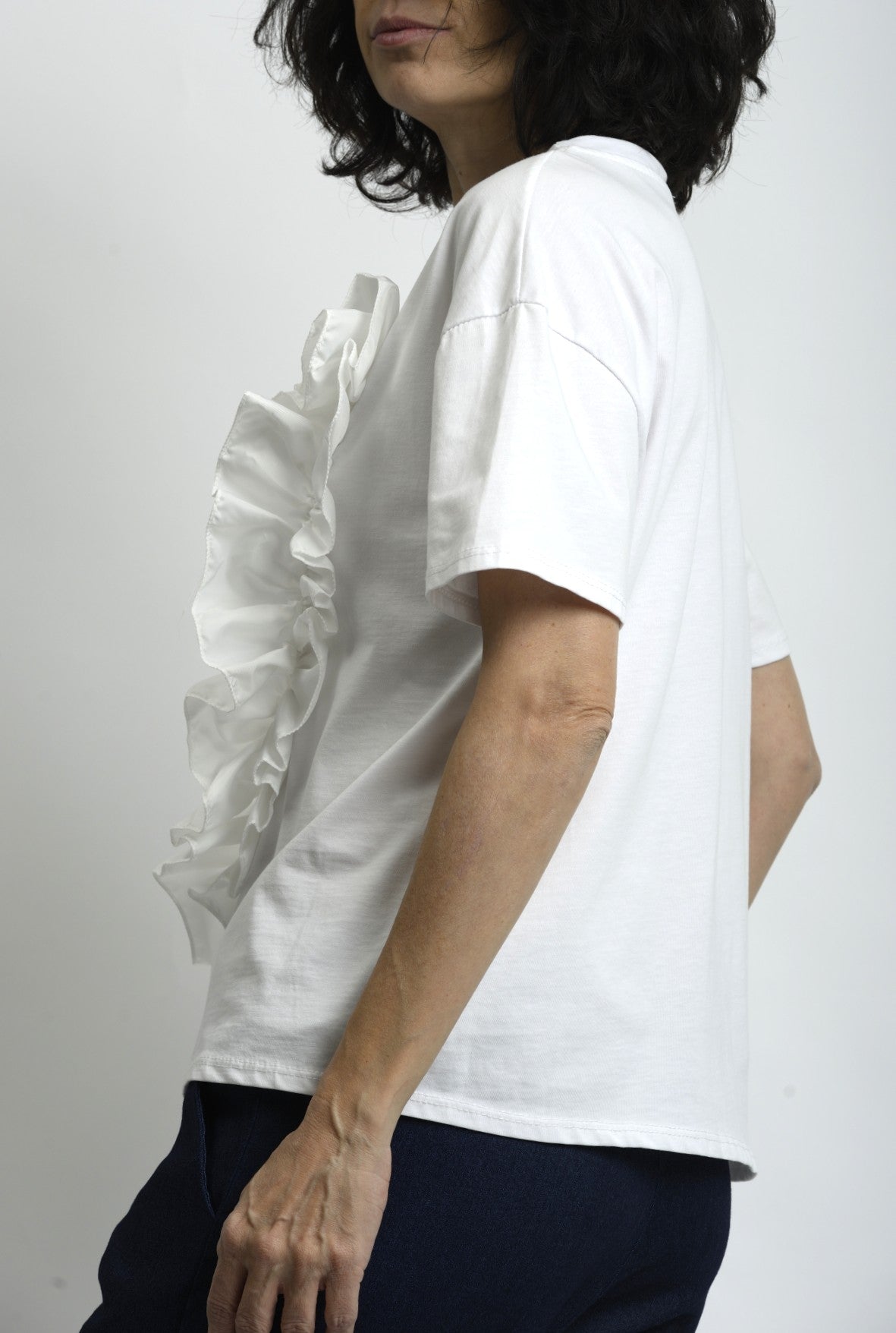 Detaliu volan amplu din fâș aplicat pe tricou, oferind contrast de textură și accent feminin.