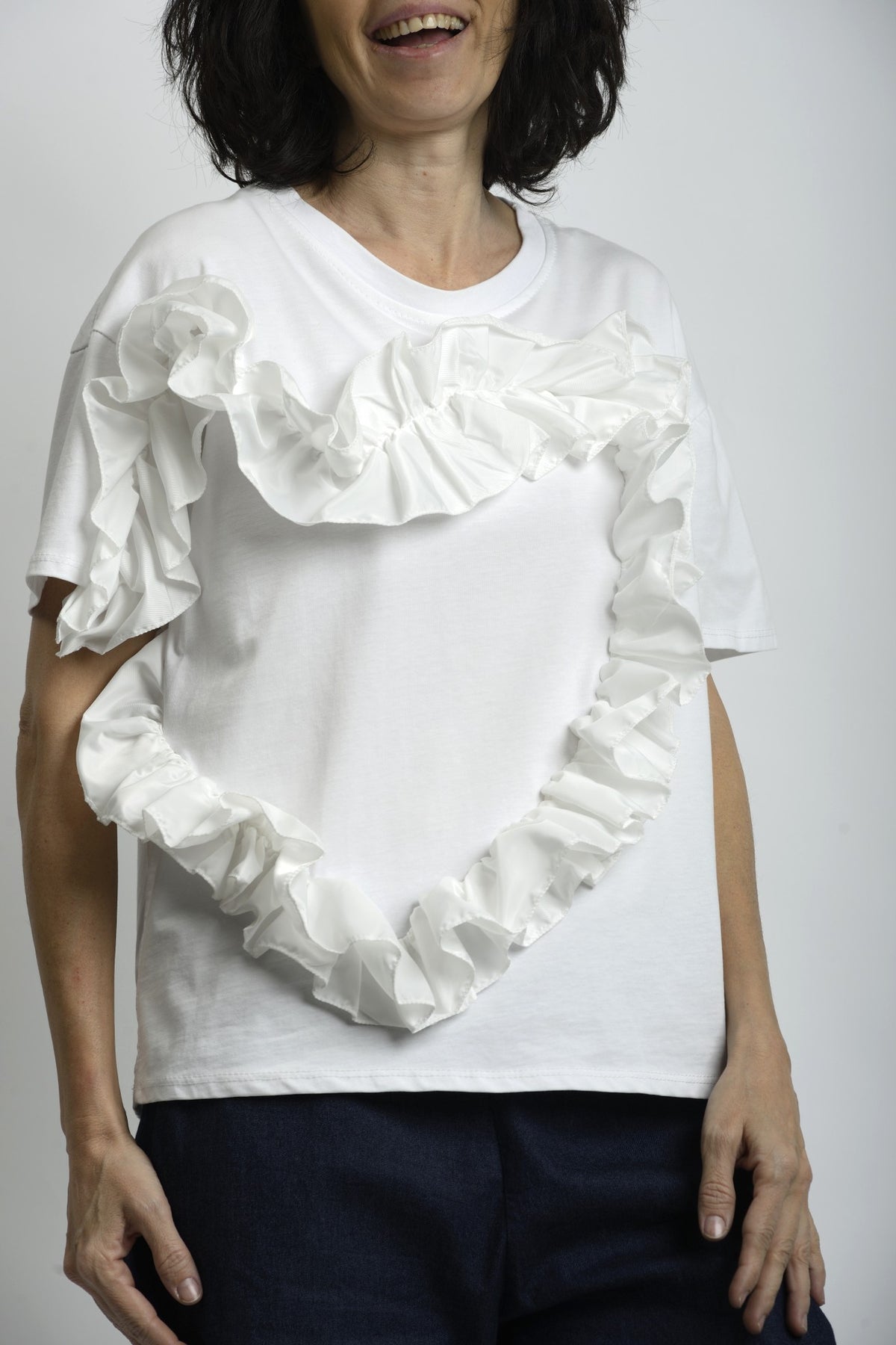 Vedere laterală a tricoului cu volan din fâș, evidențiind linia dreaptă și volumul decorativ.