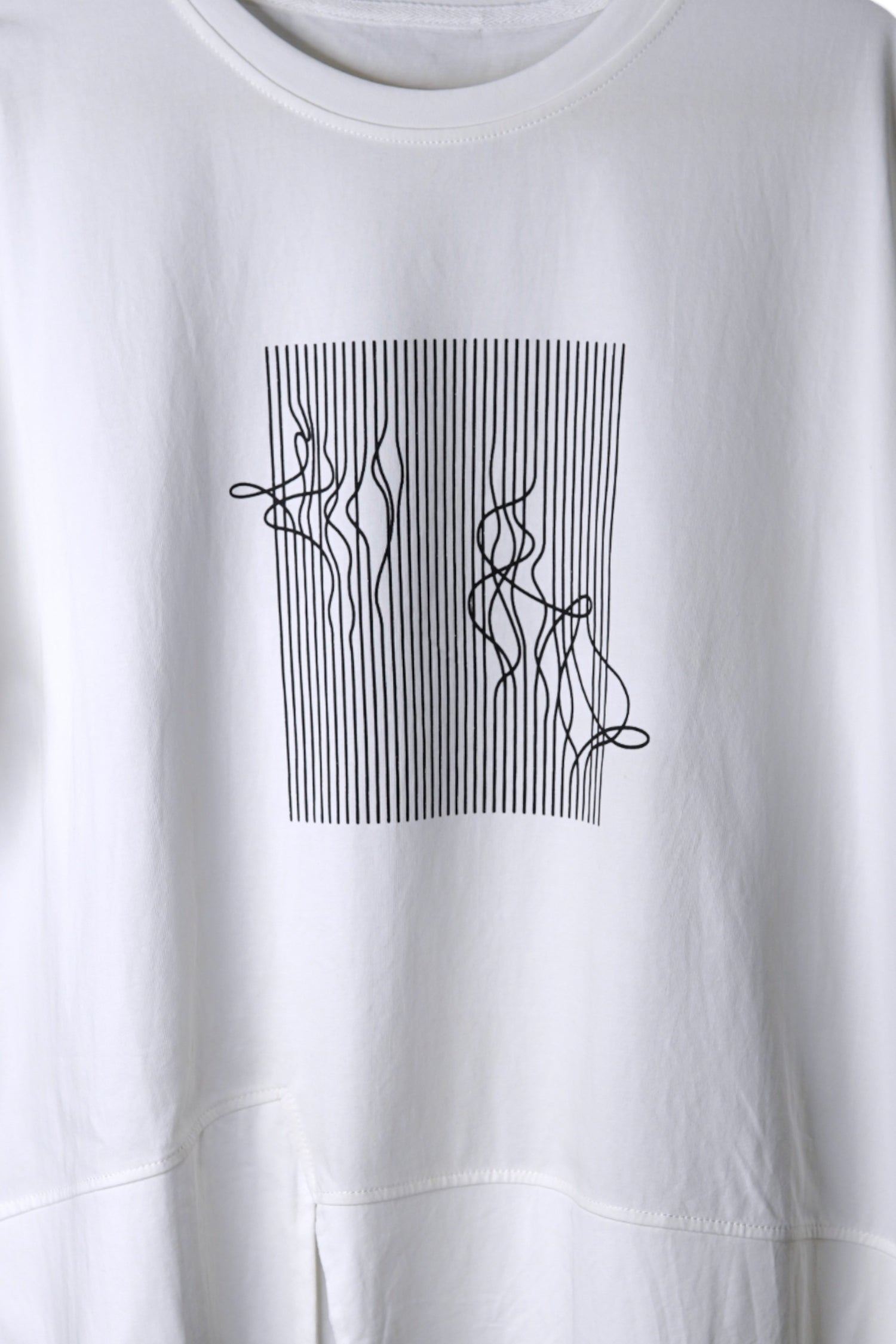 Detaliu imprimeu grafic cu linii negre ondulate pe fundal alb de tricou din bumbac