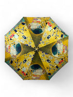 Vedere din interior a umbrelei cu imprimeu artistic Gustav Klimt și spițe metalice.