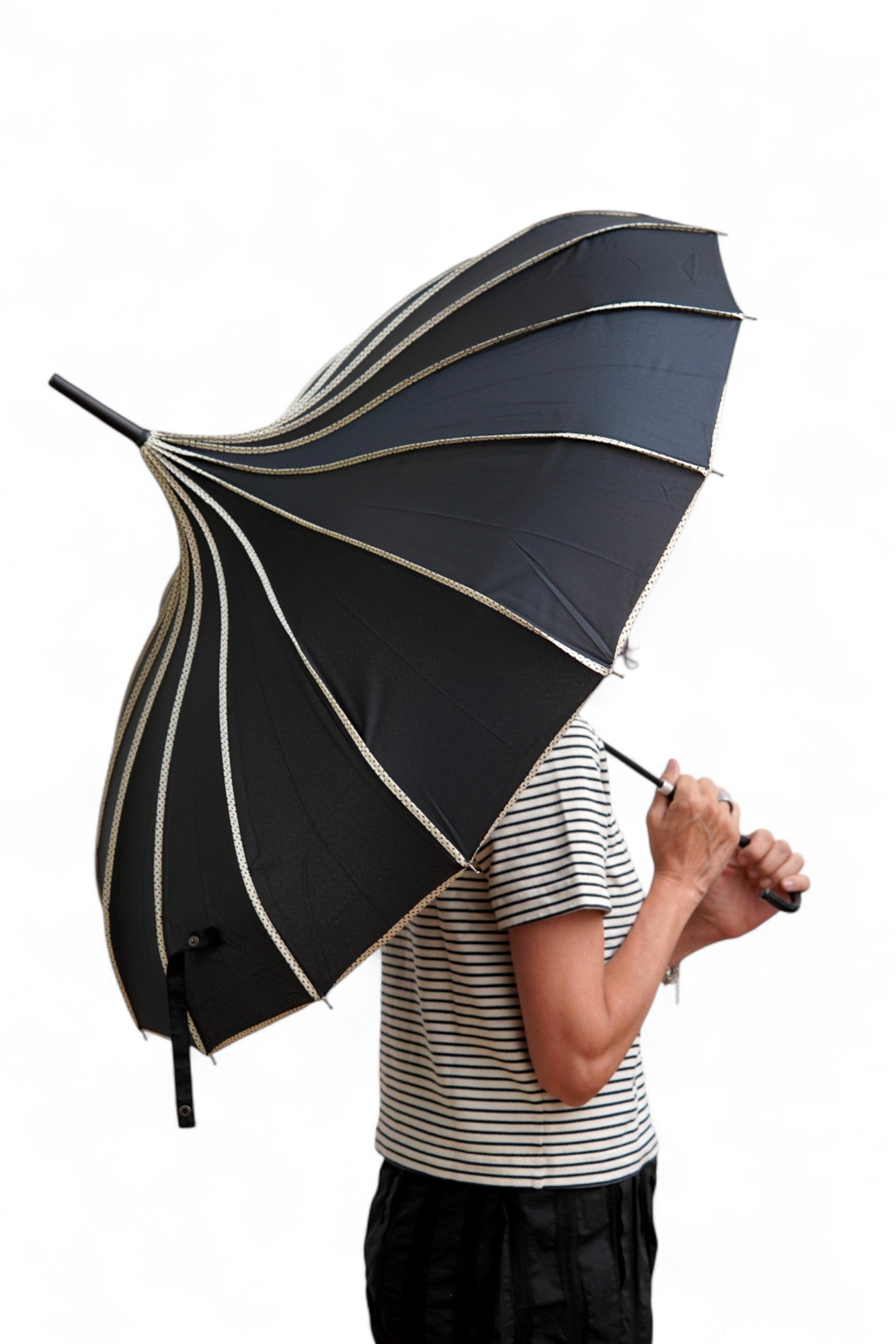 Umbrelă neagră din poliester, deschisă, cu dungi decorative deschise la culoare și structură metalică rezistentă