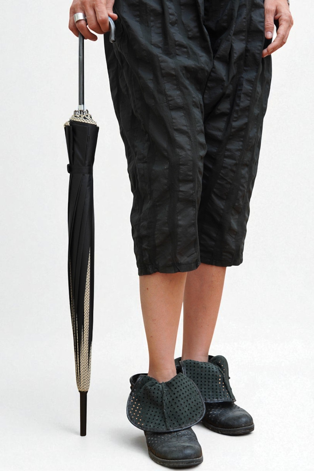 Umbrelă elegantă neagră, cu cupolă din poliester, structură metalică și mâner ergonomic din plastic, pliată și ținută în mână